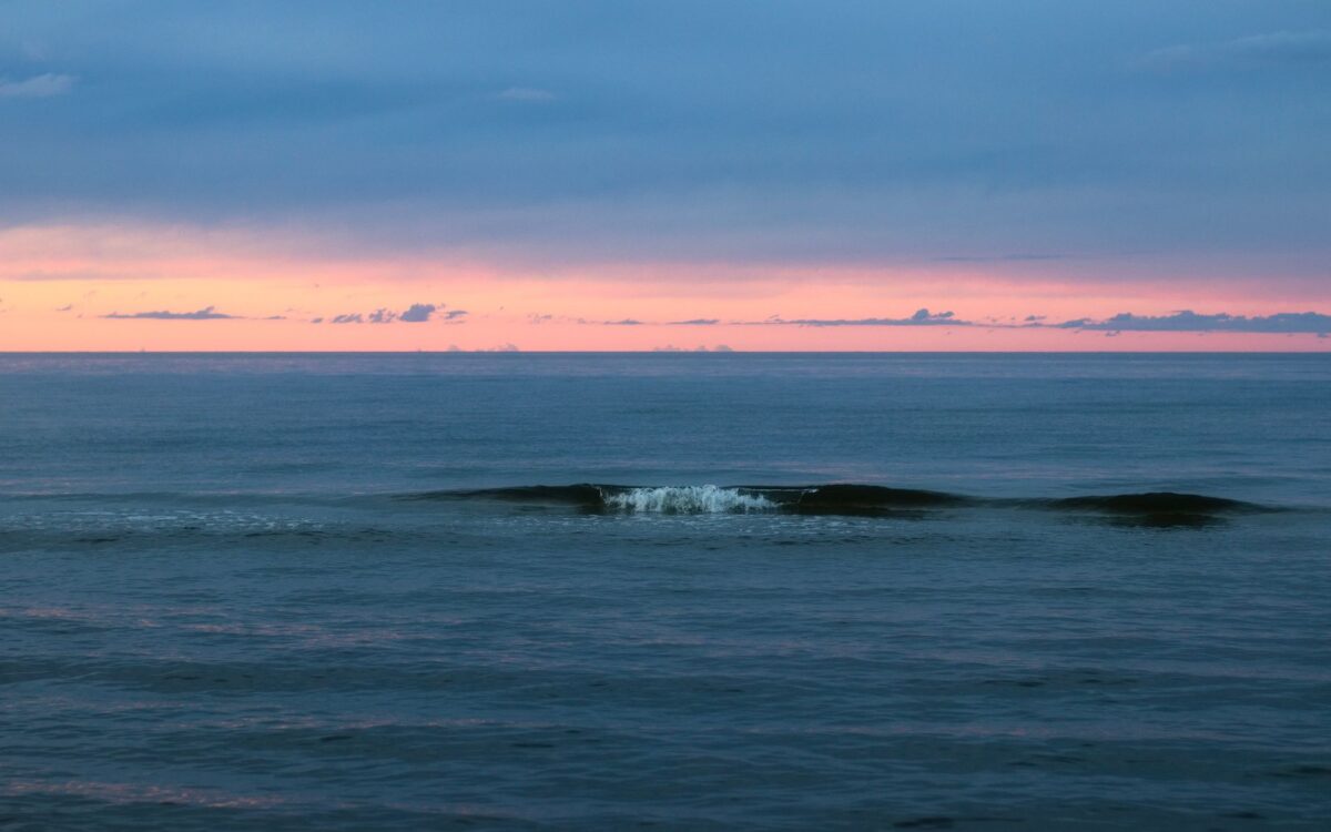 Pôr do sol em Capão da Canoa com ondas tranquilas, cenário ideal para desconexão digital e bem-estar à beira-mar